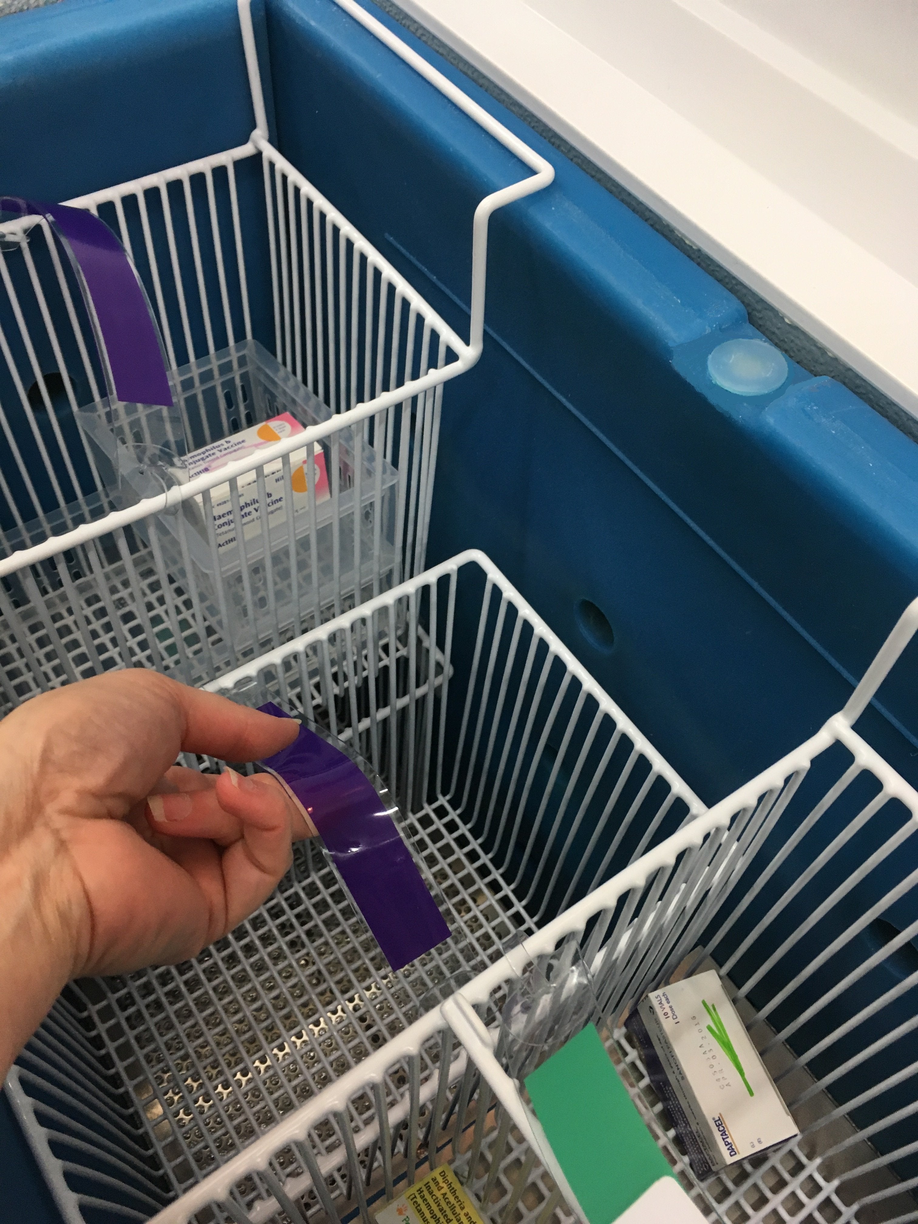 Hand removing product from the TempArmour Vaccine Refrigerator (Model BFRV84)